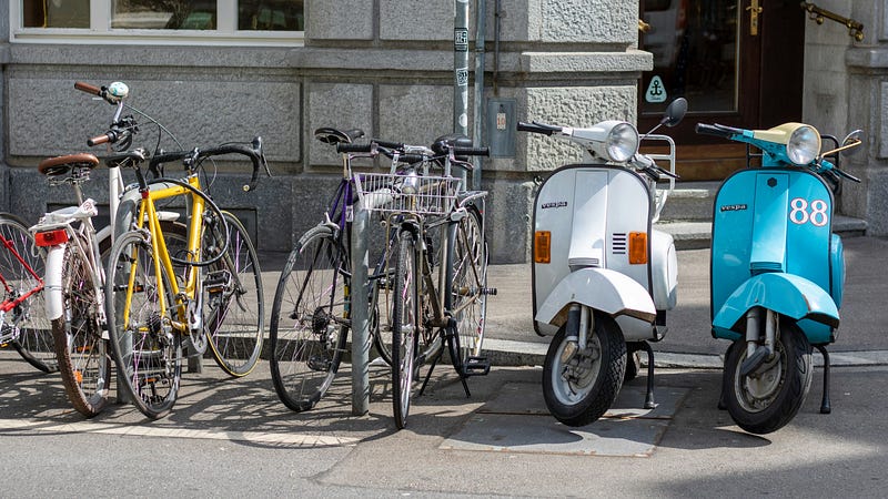 A group of bicycles ready for a race against scooters.